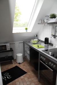 eine Küche mit einem Waschbecken und einer Theke mit einem Fenster in der Unterkunft Ferienwohnung weißes Haus in Meeschendorf