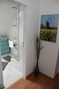ein Badezimmer mit einer Vase mit einem Gemälde an der Wand in der Unterkunft Ferienwohnung weißes Haus in Meeschendorf