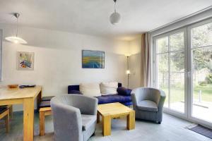 a living room with a blue couch and a table and chairs at Cubes Insel in Zingst