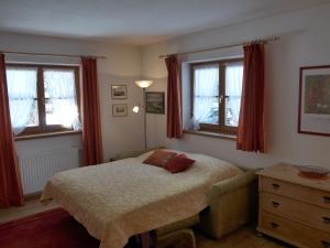 a bedroom with a bed and two windows at Haus Savoy - Appartement 1 in Kitzbühel