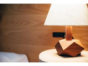 HOTEL KARUIZAWA CROSS - Vacation STAY 56407v في كارويزاوا: وجود مصباح خشبي فوق طاولة