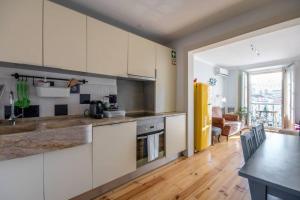 kuchnia z białymi szafkami i drewnianą podłogą w obiekcie Lisbon Heart Apartments - Blue Apartment by LovelyStay w Lizbonie