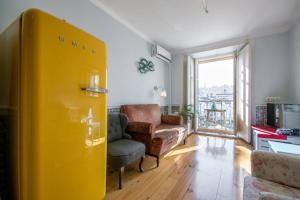salon z żółtymi drzwiami i krzesłem w obiekcie Lisbon Heart Apartments - Blue Apartment by LovelyStay w Lizbonie