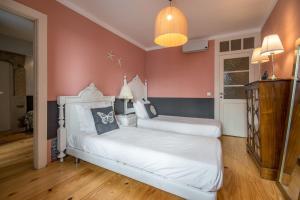 2 łóżka w pokoju z różowymi ścianami w obiekcie Lisbon Heart Apartments - Blue Apartment by LovelyStay w Lizbonie