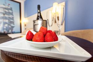 a bowl of strawberries on a table with champagne glasses at Hotel Albaida Nature in Mazagón