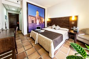 a hotel room with a bed and a large painting on the wall at Hotel Albaida Nature in Mazagón