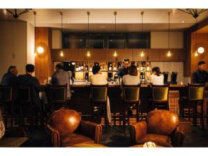 a group of people sitting at a bar in a restaurant at HOTEL KARUIZAWA CROSS - Vacation STAY 56456v in Karuizawa