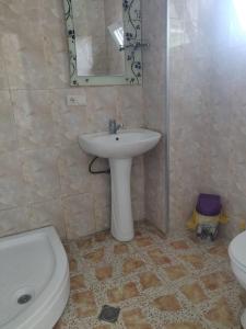 a bathroom with a sink and a toilet and a mirror at Lily Pearls Inn in K'obulet'i