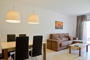 a living room with a table and a couch at Rentalmar Paradise Family con parking incluido in Salou