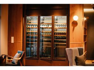 a display case with a lot of wine bottles at HOTEL KARUIZAWA CROSS - Vacation STAY 56467v in Karuizawa