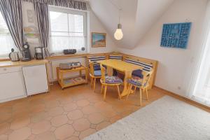 uma cozinha com mesa e cadeiras num quarto em Strandlust - Whg 14 em Zingst
