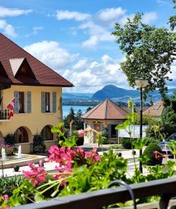 a view of a house with flowers in the foreground at H&ocirc;tel Restaurant Villa Riva in Veyrier-du-Lac