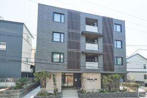 Un grand bâtiment en briques avec un escalier se trouve devant. dans l'établissement ReLA Higashimatsudo - Vacation STAY 67551v, à Matsudo