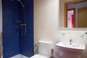 a bathroom with a toilet and a sink and a mirror at Rentalmar Paradise Family con parking incluido in Salou