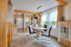 - une cuisine et une salle à manger avec une table et des chaises dans l'établissement Ferienhaus Teuber, à Trassenheide