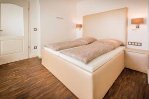 a bedroom with a large white bed in a room at "Villa Anker" 1 Etage - links in Fehmarn