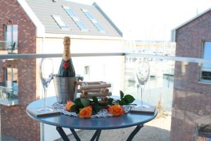 a table with a bottle of champagne and two glasses at Ostsee - Appartement Nr 97 "Albatros" im Strand Resort in Heiligenhafen