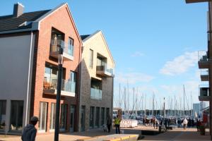 a group of buildings next to a marina with sailboats at Ostsee - Appartement Nr 97 "Albatros" im Strand Resort in Heiligenhafen