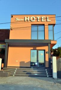 a building with a sign on the side of it at Garni Hotel Kaća in Kragujevac