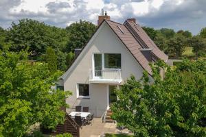 una casa blanca con techo de gambrel en Dein Ferienhaus Strandstrasse, en Fehmarn