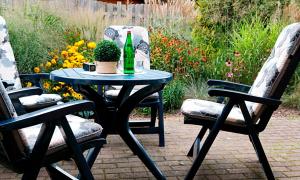 a table with a bottle of wine and two chairs at Haus Birkenweg in Westerrönfeld
