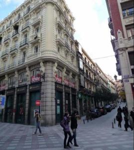 a group of people walking in front of a building at Hostal Hispalense in Madrid