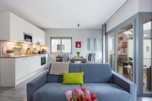ハイリゲンハーフェンにあるOstsee - Appartement "Promenade74" im Strand Resortのリビングルーム(青いソファ付)、キッチン