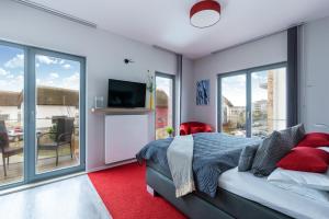 una camera con letto, TV e finestre di Ostsee - Appartement "Promenade74" im Strand Resort a Heiligenhafen