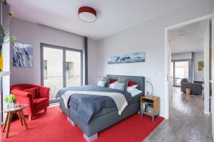 a bedroom with a bed and a red rug at Ostsee - Appartement "Promenade74" im Strand Resort in Heiligenhafen