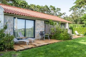 a wooden deck with chairs and a table in a yard at Quinta Vale da Roca in Sintra