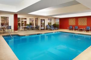 uma piscina num quarto de hotel com cadeiras e mesas em Holiday Inn Express Tifton, an IHG Hotel em Tifton