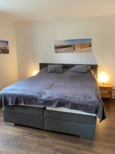 ハイリゲンハーフェンにあるFerienwohnung Mariaのベッドルーム1室(大型ベッド1台、青い毛布付)
