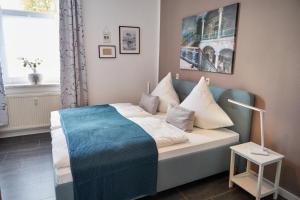 - une chambre avec un lit bleu et des oreillers dans l'établissement City-Apartment 1, à Bernburg