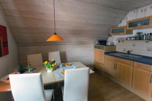 cocina con mesa y sillas blancas en Ferienwohnung Glückauf, en Peiting