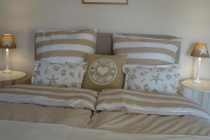 a bed with striped pillows and pillows on it at Hoheluft am Wittensee Apt 3 in Groß Wittensee
