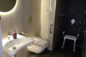 uma casa de banho com um lavatório, um chuveiro e um banco em Vega Suites em Antalya