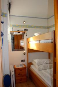 a bedroom with two bunk beds and a mirror at Hinzberg, P-EG-4 in Heiligenhafen