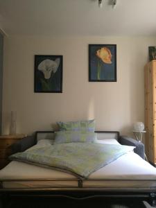 a bed in a bedroom with two pictures on the wall at Gode Wind in Eckernförde