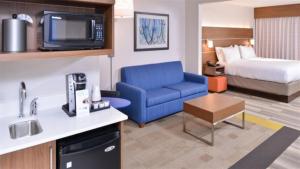 Habitación de hotel con sofá azul y cama en Holiday Inn Express Hotel & Suites Mount Juliet - Nashville Area, an IHG Hotel, en Mount Juliet