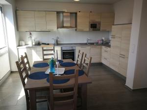 a kitchen with a table and chairs and a kitchen with white cabinets at Nike -barrierearm- in Burg auf Fehmarn