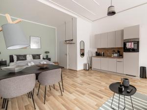 a kitchen and a living room with a table and chairs at Limehome Villach Kirchenplatz in Villach