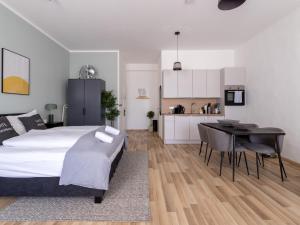 a bedroom with a bed and a table and a kitchen at limehome Villach Kirchenplatz in Villach