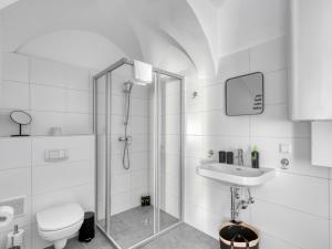 a bathroom with a shower and a toilet and a sink at limehome Villach Kirchenplatz in Villach