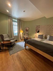 a large bedroom with a large bed and a chair at Hotel Zur Alten Brücke in Heidelberg