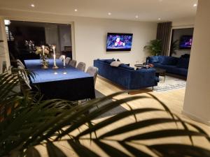 ein Wohnzimmer mit einem Tisch und einem blauen Sofa in der Unterkunft Villa Grötvik in Halmstad