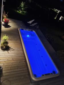 a blue swimming pool on a deck at night at Villa Grötvik in Halmstad