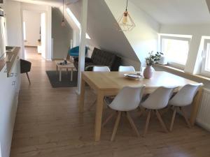 a dining room and living room with a table and chairs at Nordische Ferienwohnung auf Gut Bennewohld LL in Heide
