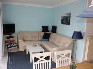 ein Wohnzimmer mit einem Sofa und einem Tisch in der Unterkunft Ferienwohnung 1066 App 1 in Tossens in Tossens