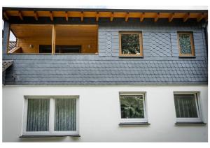 a white house with four windows and a roof at Ferienwohnung Monteurwohnung Zu Hause in Lennestadt