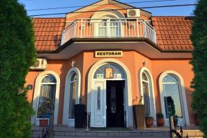 an orange building with a balcony on top of it at Garni Hotel Kaća in Kragujevac